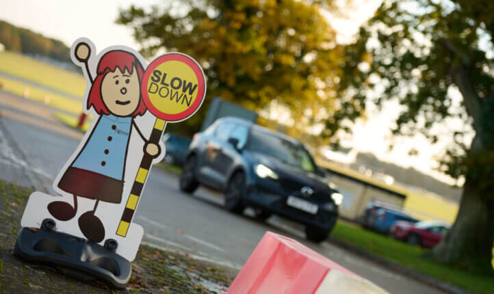 Car driving past slow down sign