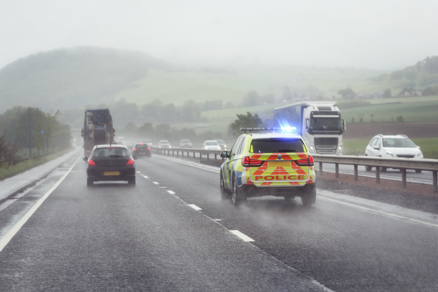 Police driving in the rain on a dual carriage way