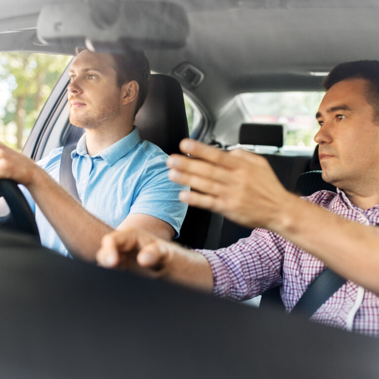 Trainer and student in car on road