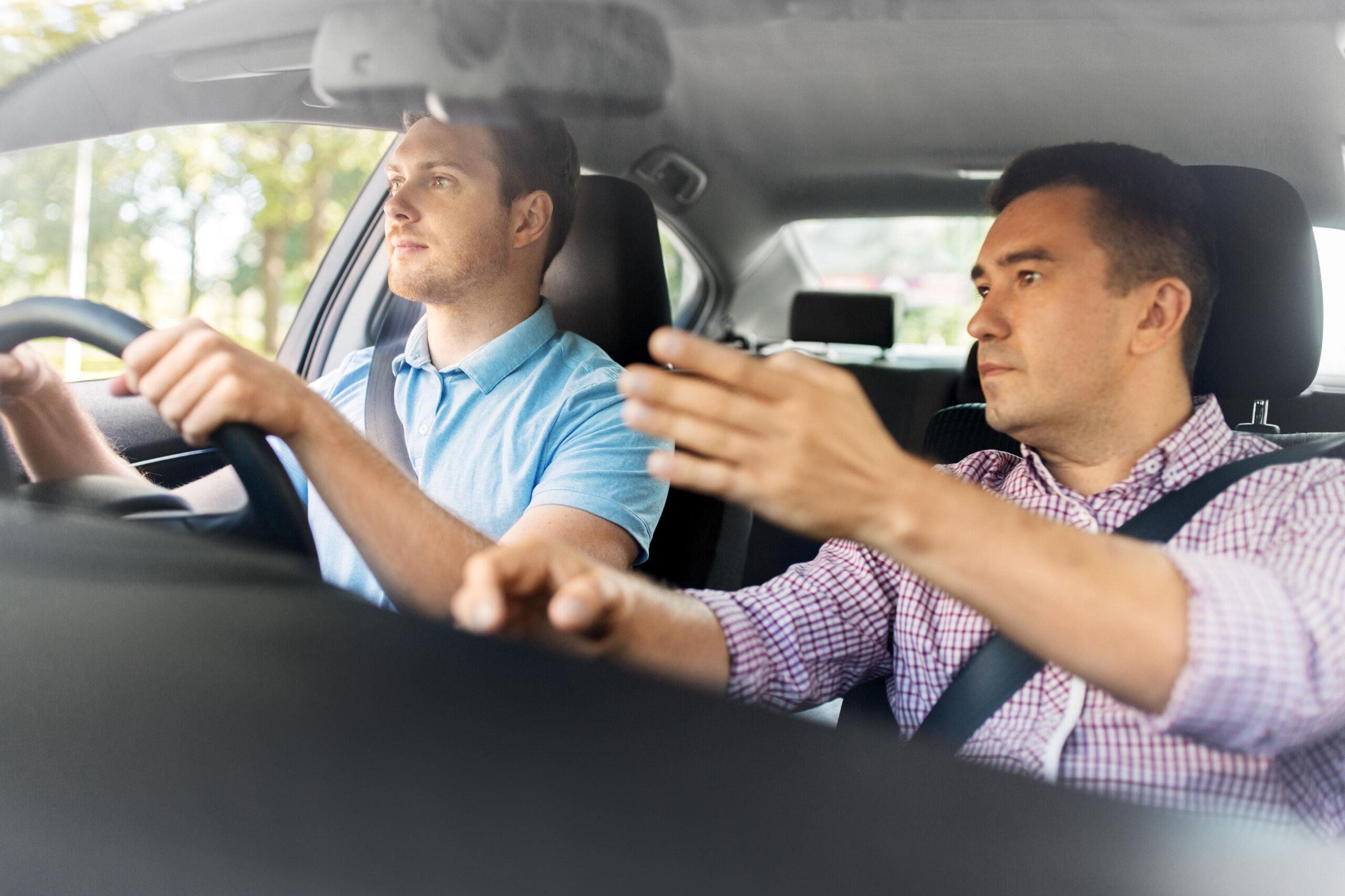 Trainer and student in car on road